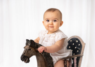 Babyfotografering Freya 9 månader på gunghäst i Kristianstad nära Lund