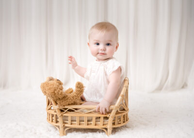 Vera 7 månader i säng babyfotografering i studio i Kristianstad nära Sölvesborg
