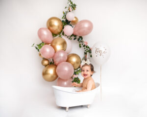 Cakesmash fotografering Ava i mjölkbad med rosa ballonger i studio i Kristianstad nära Lund