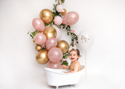 Cakesmash fotografering Ava i mjölkbad med rosa ballonger i studio i Kristianstad nära Lund