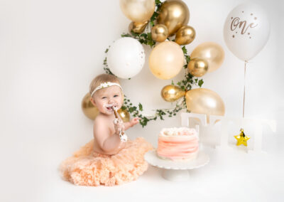 Cakesmash fotografering Vera ett år i tyllkjol med tårta och ballonger i Kristianstad nära Hässleholm och Sölvesborg