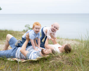 Lekfull familjefotograferingpå stranden i Åhus nära Kristianstad barnen flyger