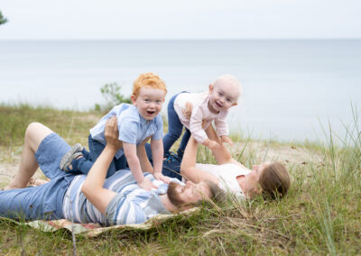 Lekfull familjefotograferingpå stranden i Åhus nära Kristianstad barnen flyger