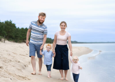 Familjefotografering vid havet i Åhus när Kristianstad familje som håller varandra i han