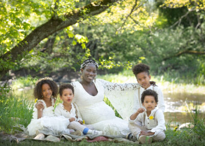 Utomhus Gravidfotografering sommar afrikansk kvinna med syskon i lånad klänning i Kristianstad nära till Lund och Hässleholm