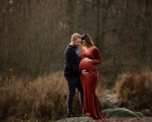 Utomhus gravidfotografering vinter med partner i lånad klänning i Kristianstad nära Eslöv och Lund