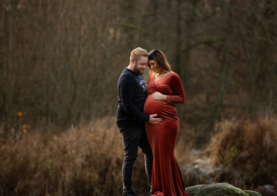 Utomhus gravidfotografering vinter med partner i lånad klänning i Kristianstad nära Eslöv och Lund